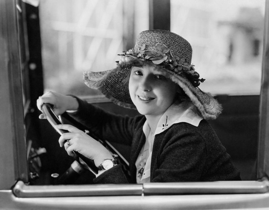 Femme au volant d'une voiture ancienne