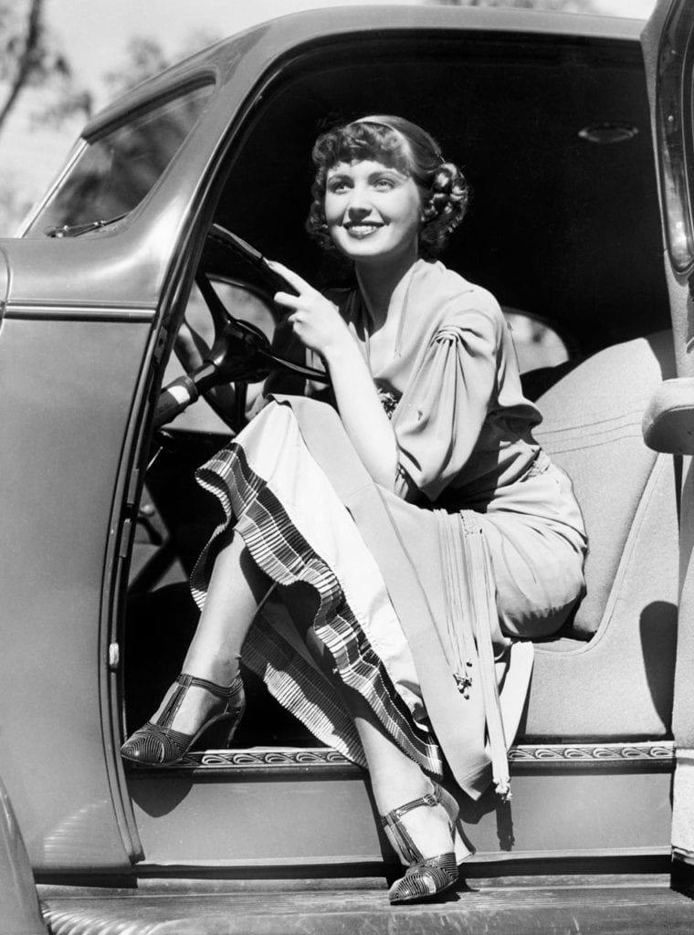 Femme souriante en voiture ancienne
