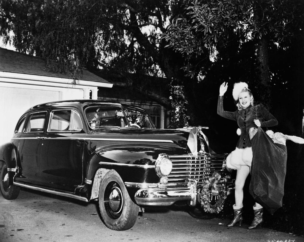 Femme pose devant une voiture ancienne