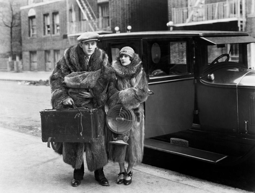 Couple chaudement vêtu devant voiture de collection