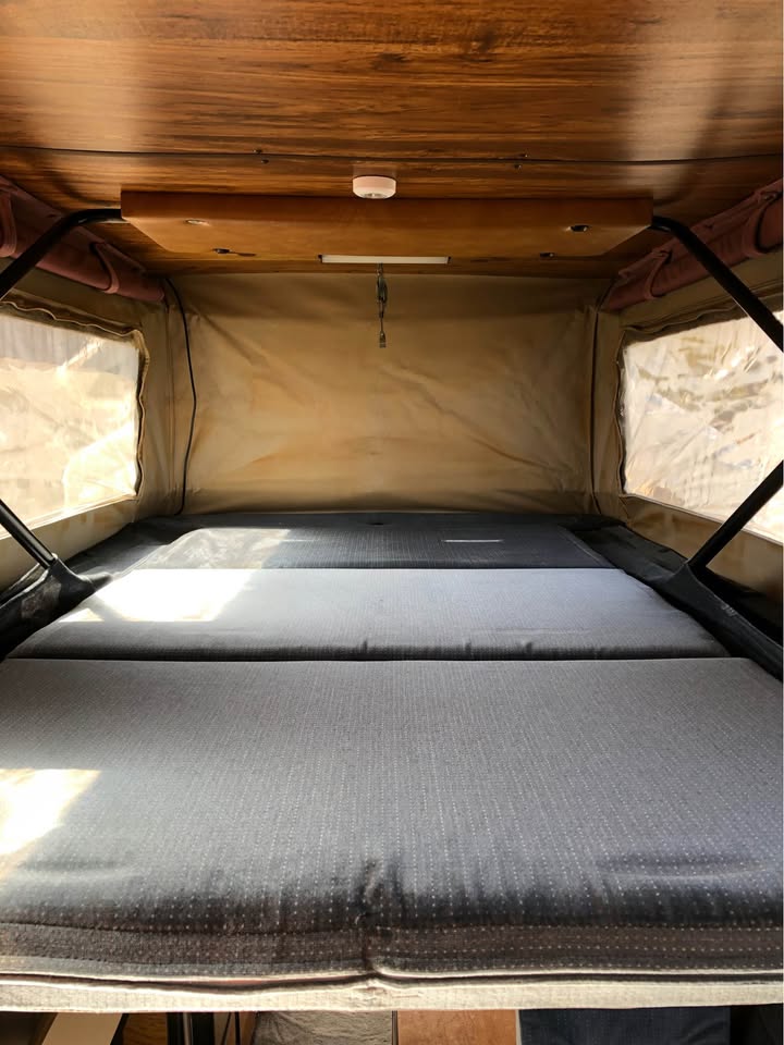 Couchage à l'étage sous le toit relevable du Ford E150