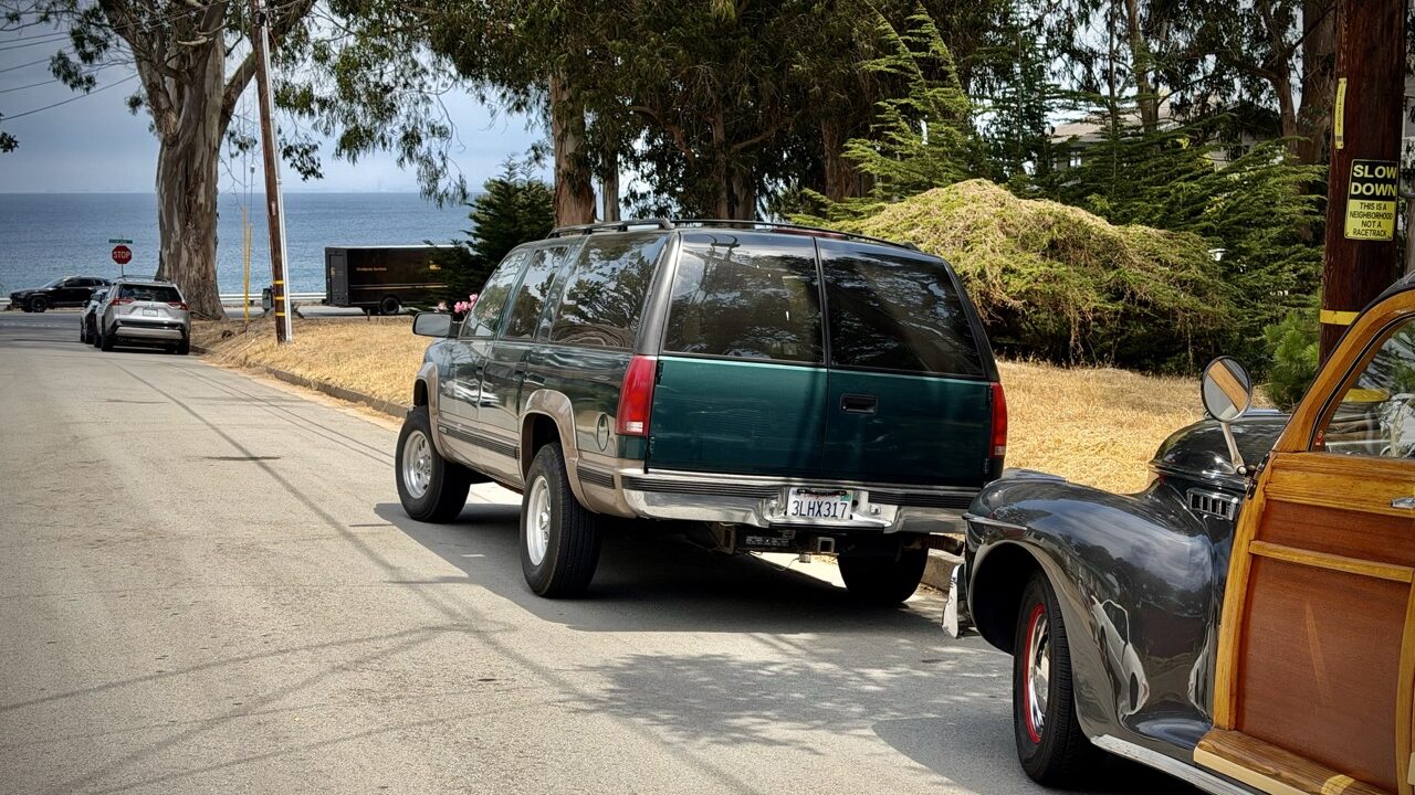 Le Suburban 1995 à côté d'un woody wagon à Monterey