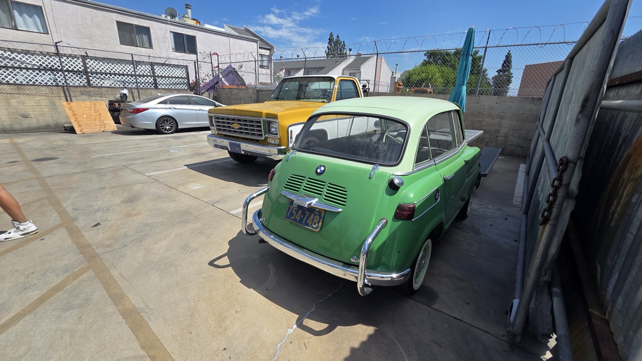 BMW 600 verte et pick-up Chevrolet C10 jaune dans la cour d'un atelier californien