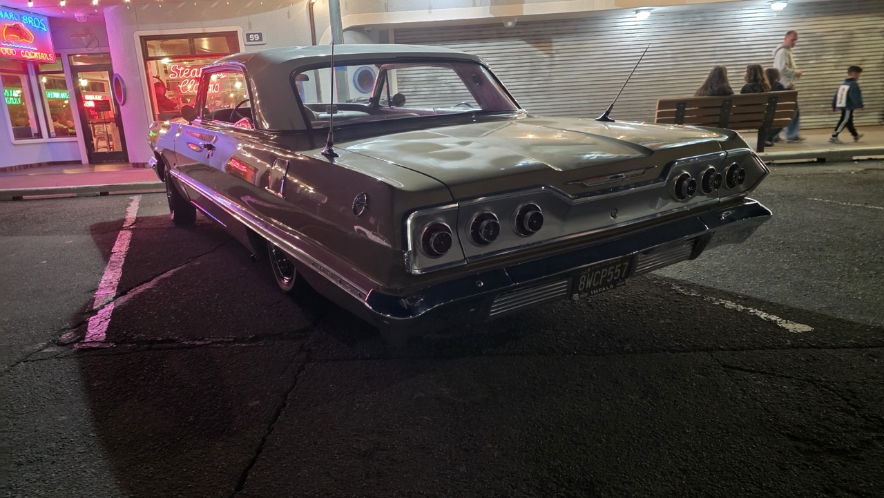 Chevrolet Impala 1963 dorée sous les néons du Municipal Wharf de Santa Cruz, la nuit