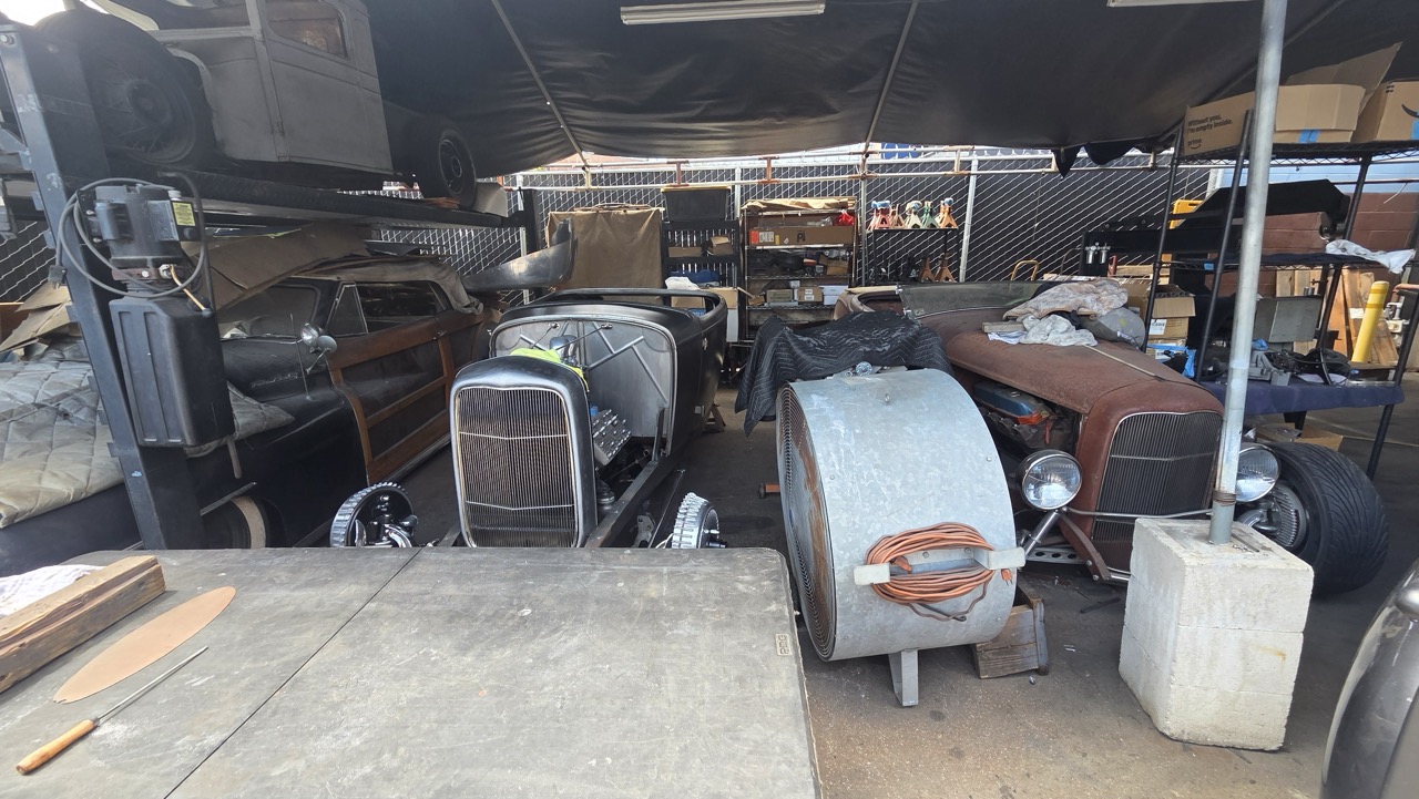 Carrosseries de Ford 1932 en attente sous une bâche dans la cour d'un atelier de hot rods