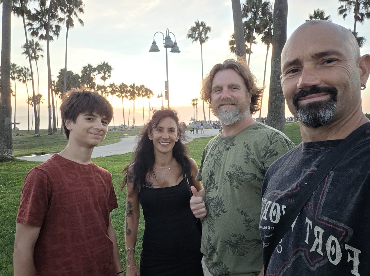 Les quatre voyageurs sur la pelouse de Venice Beach au coucher du soleil